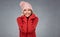 Young woman portrait on gray wearing in red warm winter clothes.