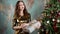 Young woman poses with Christmas gift decorated with big bow