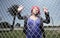 Young woman posing behind the fence