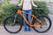 Young woman posing with bicycle on the street sport style picture.