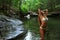 young woman posing in designer bikini at exotic location of mountain river