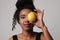 Young woman posing with lemon on white wall for skin and body care. Isolated.