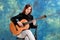 Young woman posing in the studio holding a classical guitar