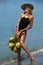Young woman posing at the tropical beach with coconuts