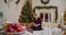 Young woman positioning Christmas presents under tree