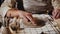 Young woman potter makes a design on the clay plate using a stamp in a leaves shape