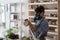 Young woman potter wearing respirator sanding ceramics with grinding block in workshop