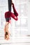 Young woman practicing antigravity yoga exercises in studio