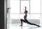 Young woman practicing crescent pose in studio