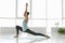 Young woman practicing crescent pose in studio