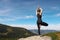 Young woman practicing outdoor yoga in mountains, back view. Fitness lifestyle