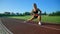 Young woman practicing side lunges at stadium.