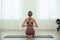 Young woman practicing thunderbolt asana in yoga studio. Vajrasana pose