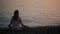 Young woman practicing yoga on the beach at sunset. calm sea