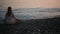 Young woman practicing yoga on the beach at sunset. calm sea