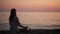 Young woman practicing yoga on the beach at sunset. calm sea