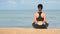 Young woman practicing yoga on the beach at sunset. Meditation, Young healthy woman practicing yoga on the beach at sunrise.