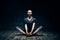 Young woman practicing yoga doing cobbler`s pose on dark room