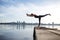 Young woman practicing yoga exercise at quiet wooden pier with c