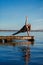 Young woman practicing yoga exercise at quiet wooden pier with city background. Sport and recreation in city rush