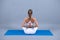 Young woman practicing yoga extended asana in studio. Sporty woman sitting on mat, doing yoga pose.