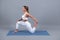 Young woman practicing yoga extended asana in studio. Sporty woman sitting on mat, doing yoga pose.