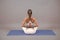 Young woman practicing yoga extended asana in studio. Sporty woman sitting on mat, doing yoga pose.