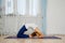 Young woman practicing yoga at home, stands in king pigeon pose