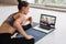 Young woman practicing yoga at home on video conference