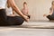 Young woman practicing yoga, instructor and group doing Sukhasan