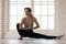 Young woman practicing yoga, Janu Sirsasana pose