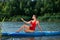 Young woman practicing yoga on light blue SUP board on river