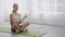 Young woman practicing yoga and meditating for relaxation and balance life on mat in the room.