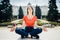 Young woman practicing yoga and meditation in park.Urban relaxation. Female meditating in a public park.Morning routine.Stress