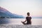 Young woman practicing yoga near the sea. Harmony and meditation concept.