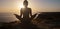 Young woman practicing yoga over sunset sea