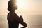 Young woman practicing yoga over sunset sea