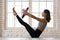 Young woman practicing yoga, Paripurna Navasana exercise with a