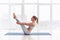 Young woman practicing yoga, sitting in Paripurna Navasana exercise at the yoga studio