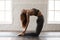 Young woman practicing yoga, standing in Ustrasana pose, Camel exercise