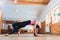 Young woman practicing yoga, stretching in variation of Reverse Table Top exercise, Bridge pose, working out, wearing