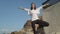 Young woman practising yoga on sunny day on the rocky sea coast.Tree posture