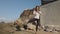 Young woman practising yoga on sunny day on the rocky sea coast.Tree posture