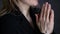 Young woman is praying. close-up female hands holding chain with a cross