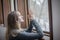 Young woman praying by window