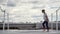 Young woman prepare to yoga practice. Girl lay out yoga mat on roof on cityscape