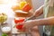 A young woman prepares bell peppers for her breakfast and is ready for a healthy meal on the table with healthy, organic