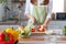 A young woman prepares bell peppers for her breakfast and is ready for a healthy meal on the table with healthy, organic