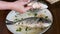 A young woman prepares dorado fish at home