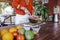 young woman preparing a healthy recipe of diverse fruits, watermelon, orange and blackberries. Using a mixer. Homemade, indoors,